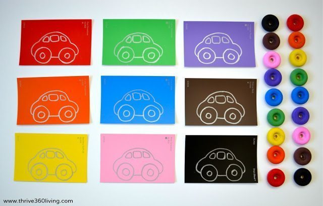 Completed car drawings and wooden wheels that will be used for the color matching game