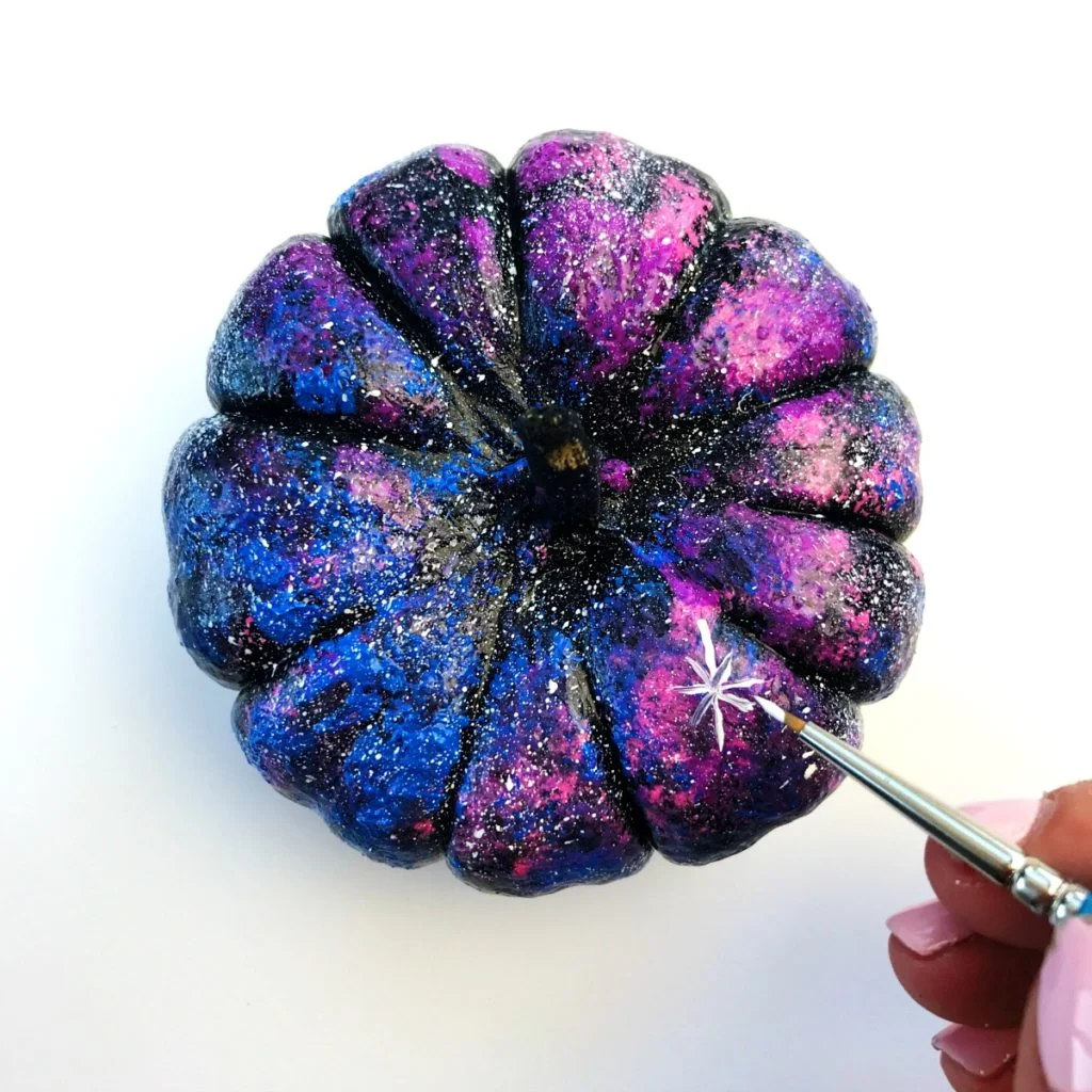 Adding details to our galaxy painted mini pumpkins