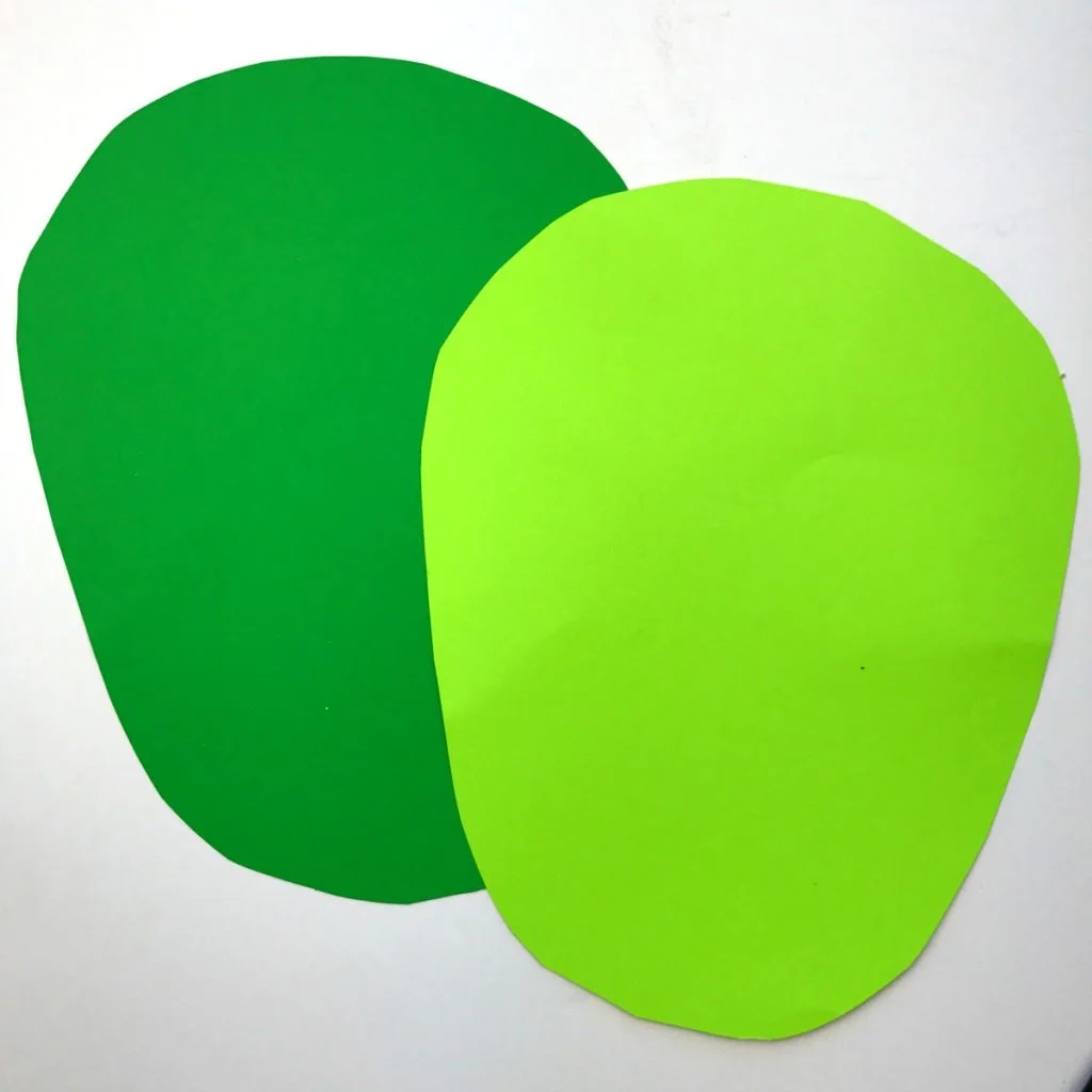 Two identical Frankenstein monster face shapes cut from light and dark green construction paper