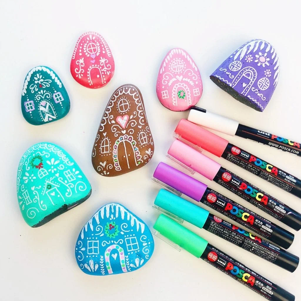Painted Rock Gingerbread Houses next to paint markers