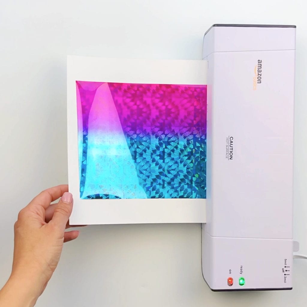 Action photo of laminating the art after it's stuck to the template