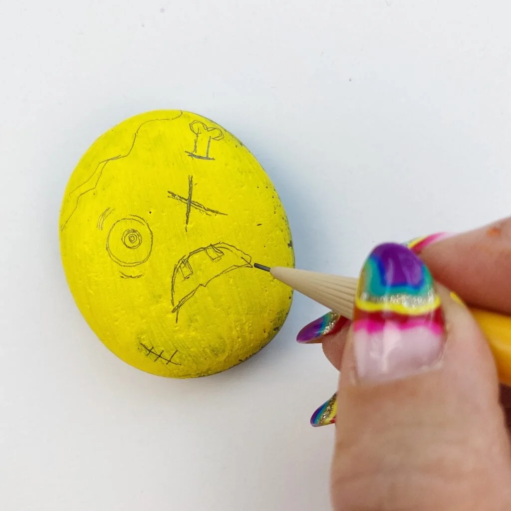 Drawing the face on the rock before painting