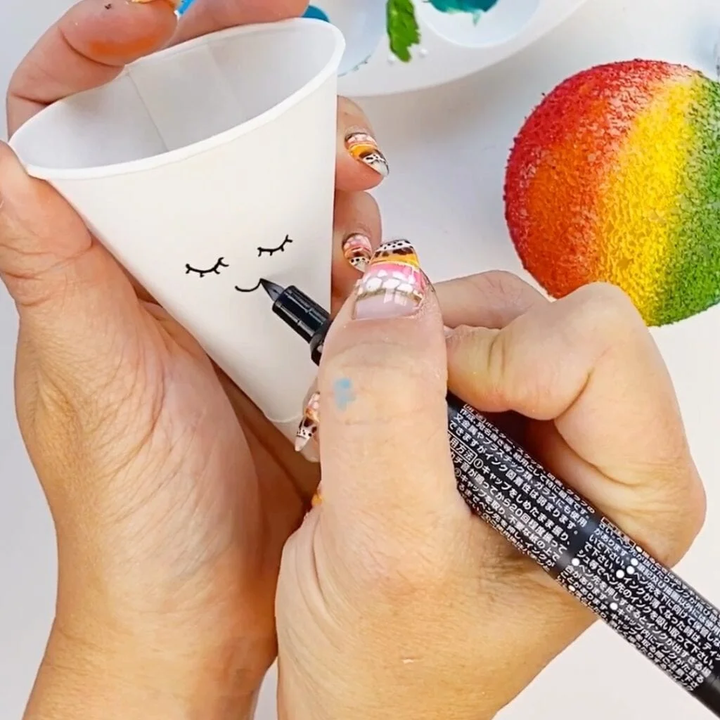 Drawing a kawaii face on the snow cone's cone part