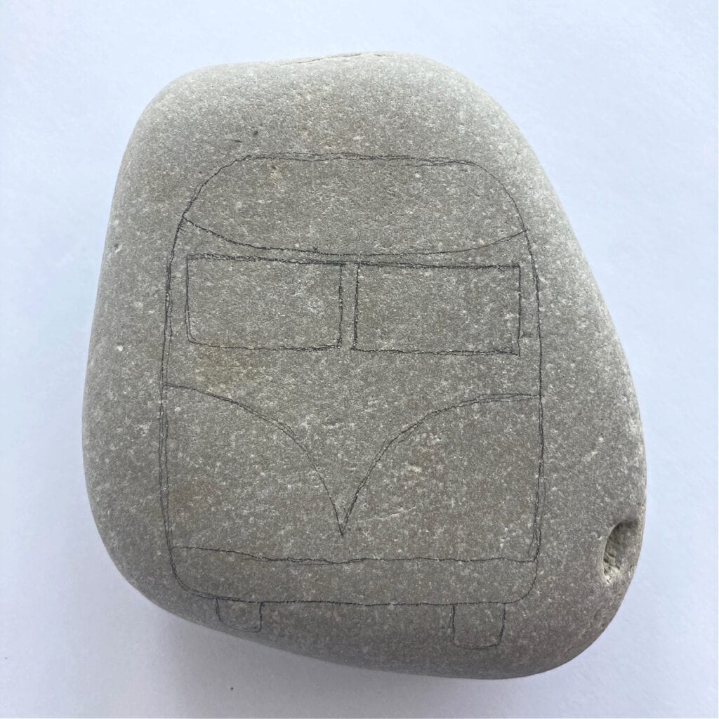 Drawing the Volkswagen Bus outline on a rock