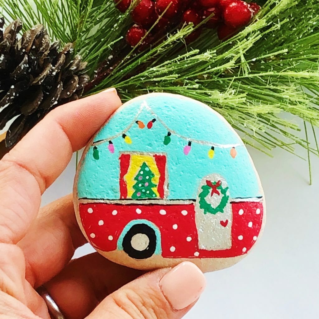 Vintage camper decorated for the holidays painted on a rock