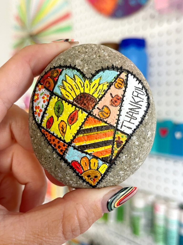 Fall Painted Rock Idea - there is a heart that looks like a quilt with a bunch of fall themes