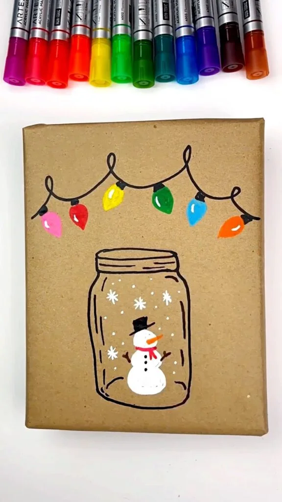 Snowman drawing is completed with snowflakes around him in the jar