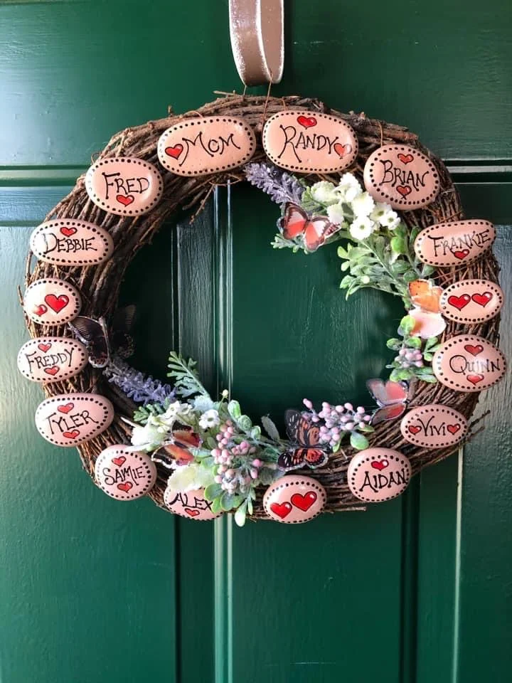 Painted rocks wreath with members of the family on it