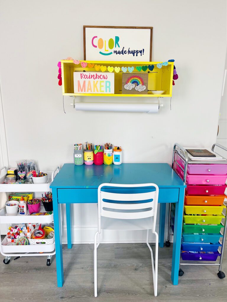 Storage carts on wheels next to a small next to create an organized craft space