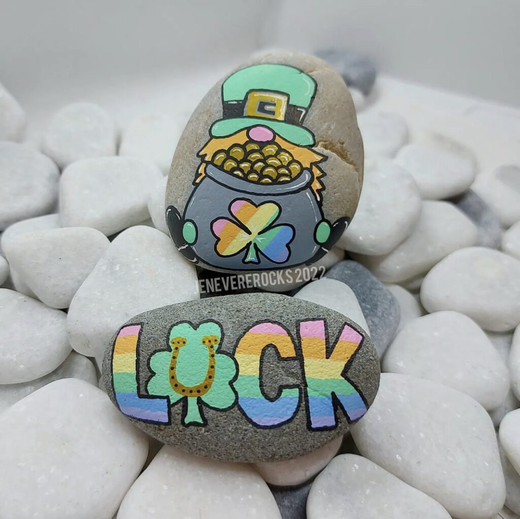There are two rocks. One is a St. Patrick's Day Gnome Painted Rock with rainbows the other says Luck with a horeshoe.