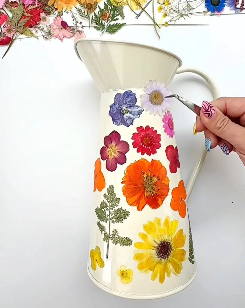Adding dried flowers to a vase.