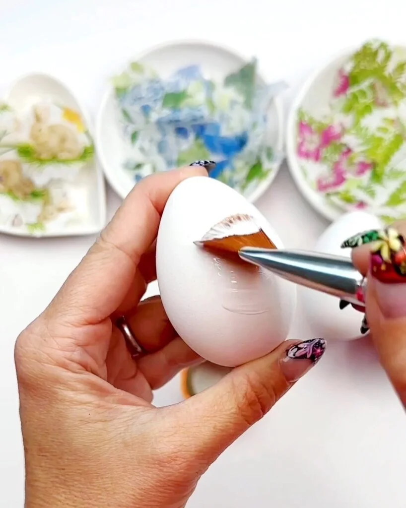 Applying Mod Podge glue to egg