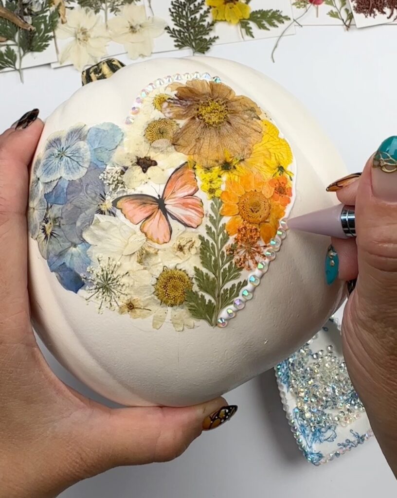 rhinestones added to pumpkin decorated with pressed flowers