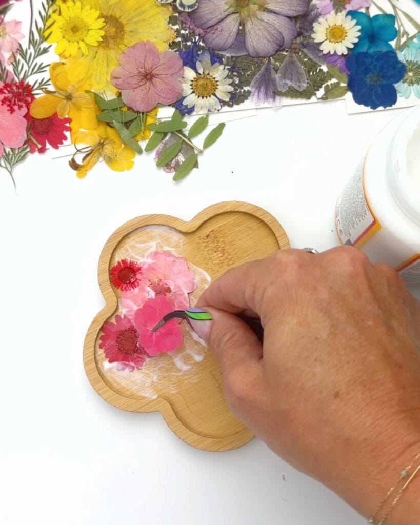 adding pressed flowers to wooden coaster